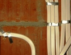 Fäst ledningar på väggen med metallremsor